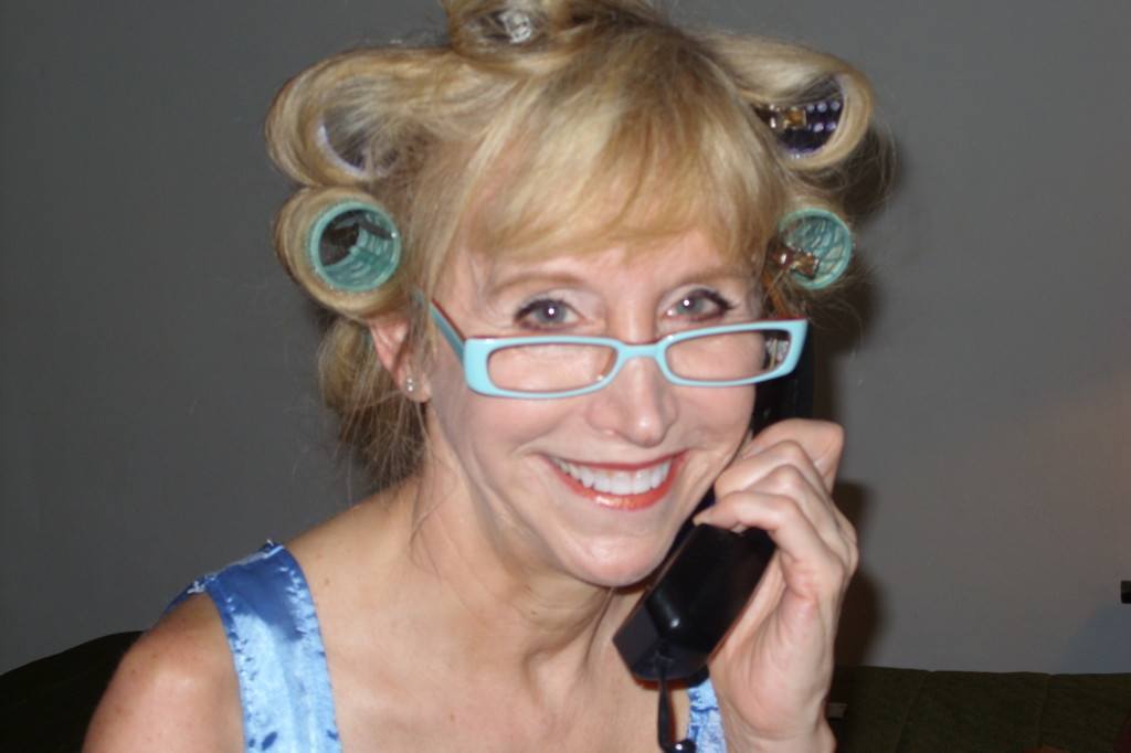 Blonde woman with hair curlers and glasses on telephone
