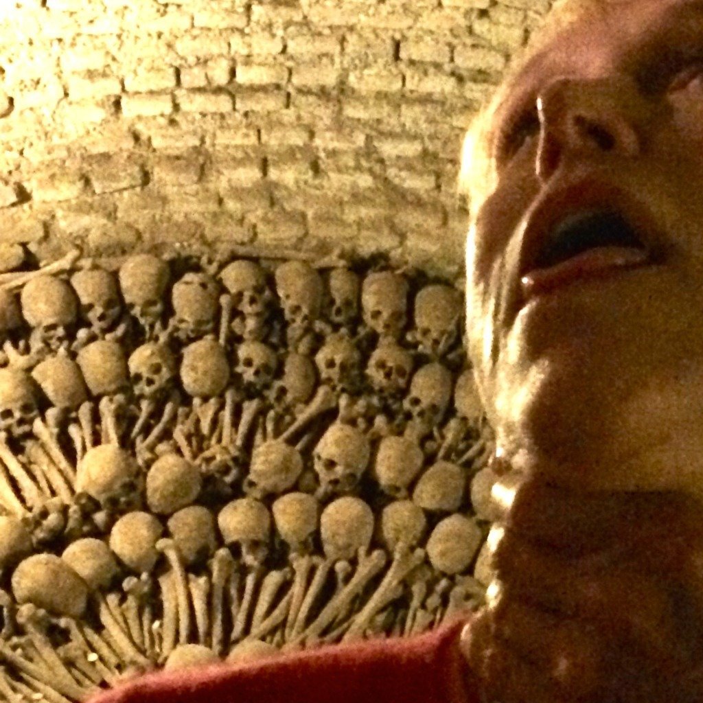 Woman taking selfie with bones in catacombs of Lglesia de San Francisco, Lima, Peru